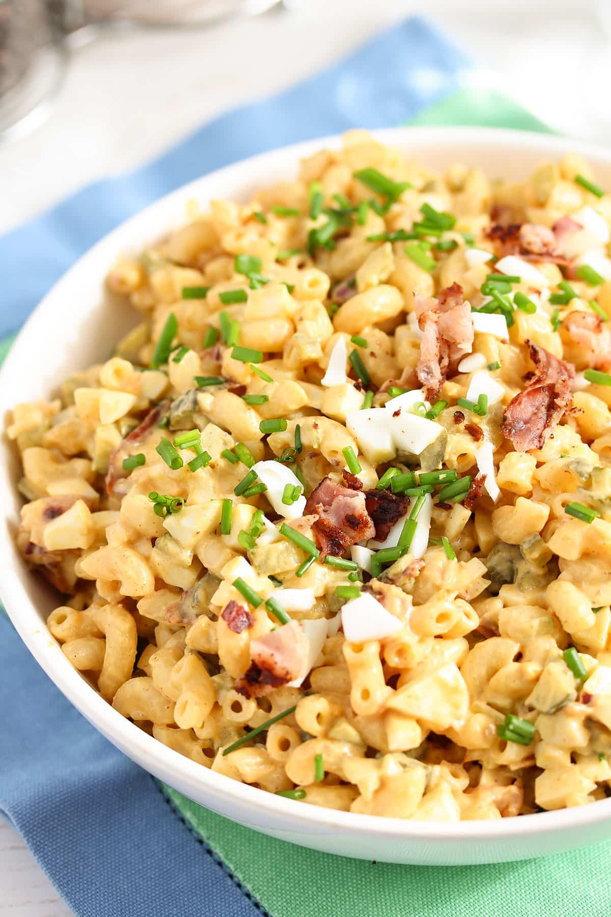 deviled egg pasta salad with chives and bacon in a bowl.