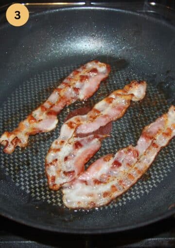 three pieces of bacon frying in a pan.
