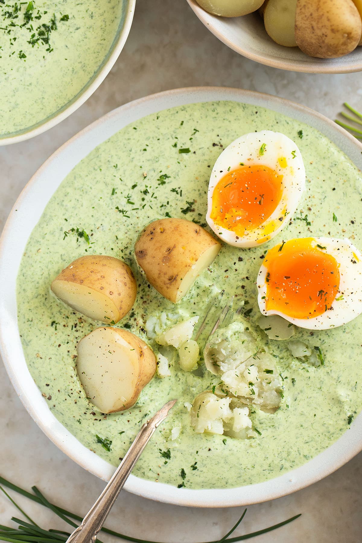 serving german green sauce with potato and egg halves on a plate.