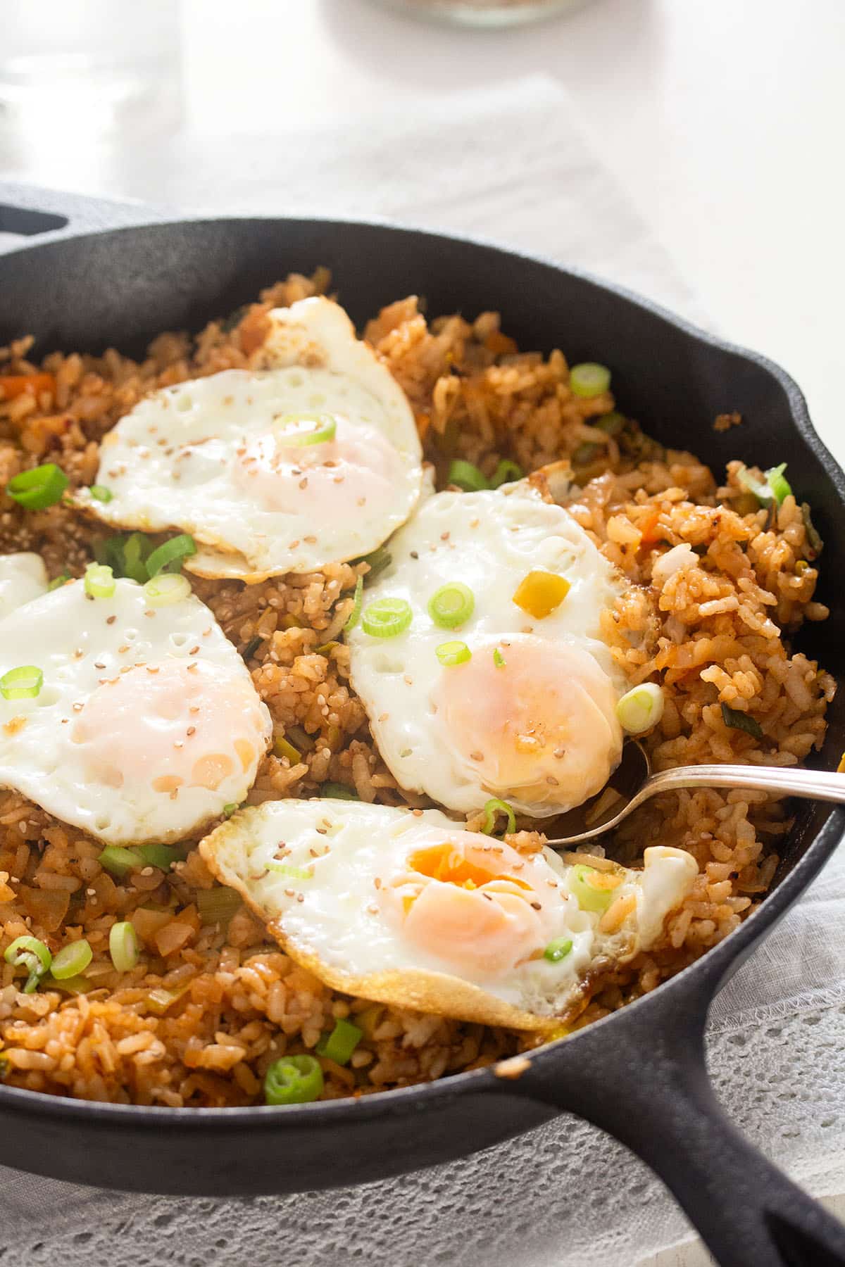 kimchi fried rice and four fried eggs in a skillet.