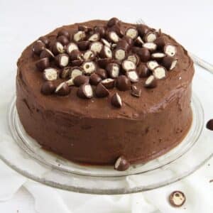 a round kinder cake covered with chocolate and decorated with halved schoko bons.