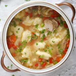 potato dumpling soup with chicken and vegetables in a vintage soup bowl.