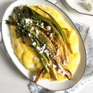 roasted green onions served on polenta with feta and a drizzle of cream.