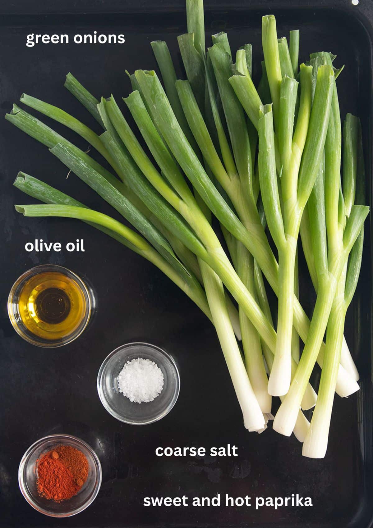 labeled ingredients for roasting green onions with oil, coarse salt, sweet and smoked paprika.