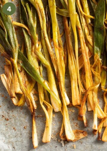roasted green onions or scallions on a lined baking sheet.
