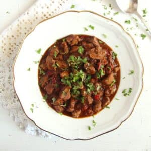 romanian lamb stew in a vintage deep plate, sprinkled with parsley.