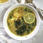romanian soup with spinach, omelet and lemon slices in a bowl.