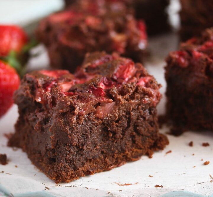 brownies with strawberries sliced on a table