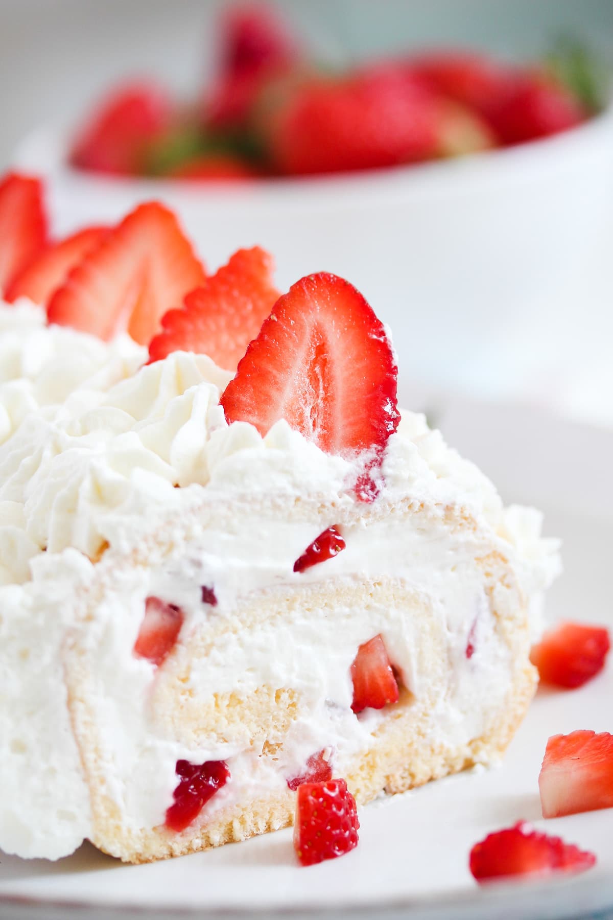 swiss roll cake with strawberries on a serving platter