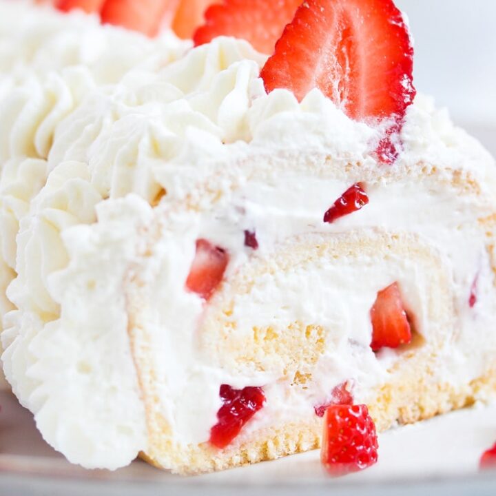 close up of sliced cream roll with strawberries