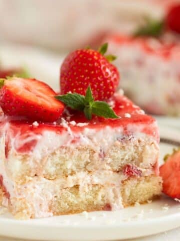 strawberry tiramisu piece topped with fresh strawberries.