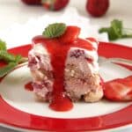 one square piece of strawberry tiramisu with strawberry sauce dripping from it.