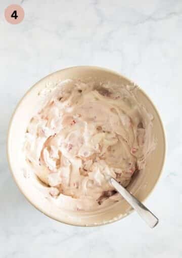 folding chopped strawberries into mascapone and quark mix for making tiramisu.