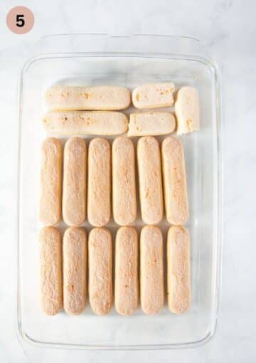 arranged and soaked ladyfingers in a rectangular dish for making tiramisu.