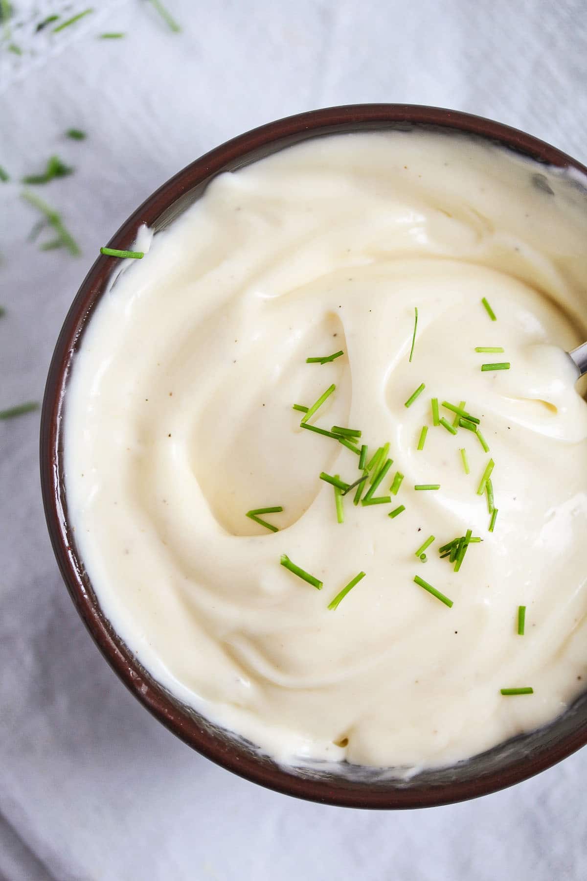 close up of a bowl with homemade mayonnaise sprinkled with chives