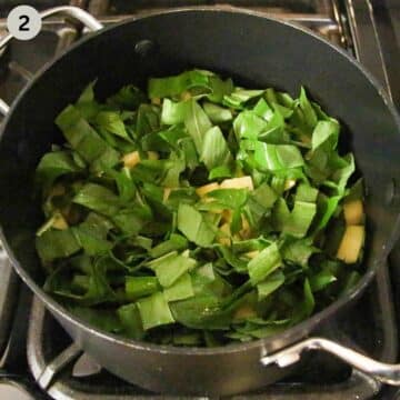 adding fresh, chopped wild garlic to potatoes in a pot to make soup.