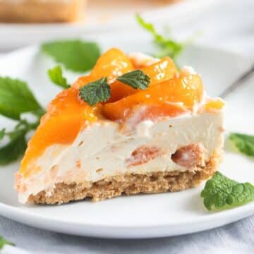 super creamy slice of apricot cheesecake garnished with lemon balm leaves.