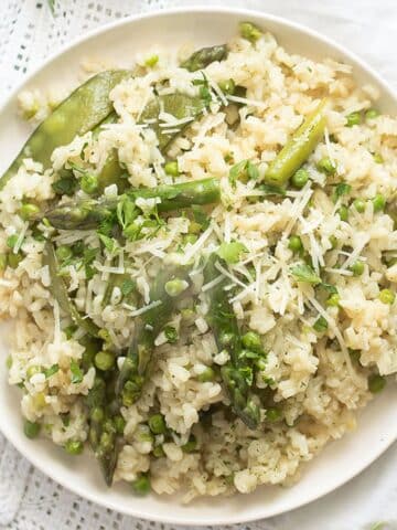 pea and asparagus risotto sprinkled with parmesan overhead view.