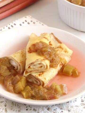 creme fraiche crepes served with rhubarb compote on a small plate.