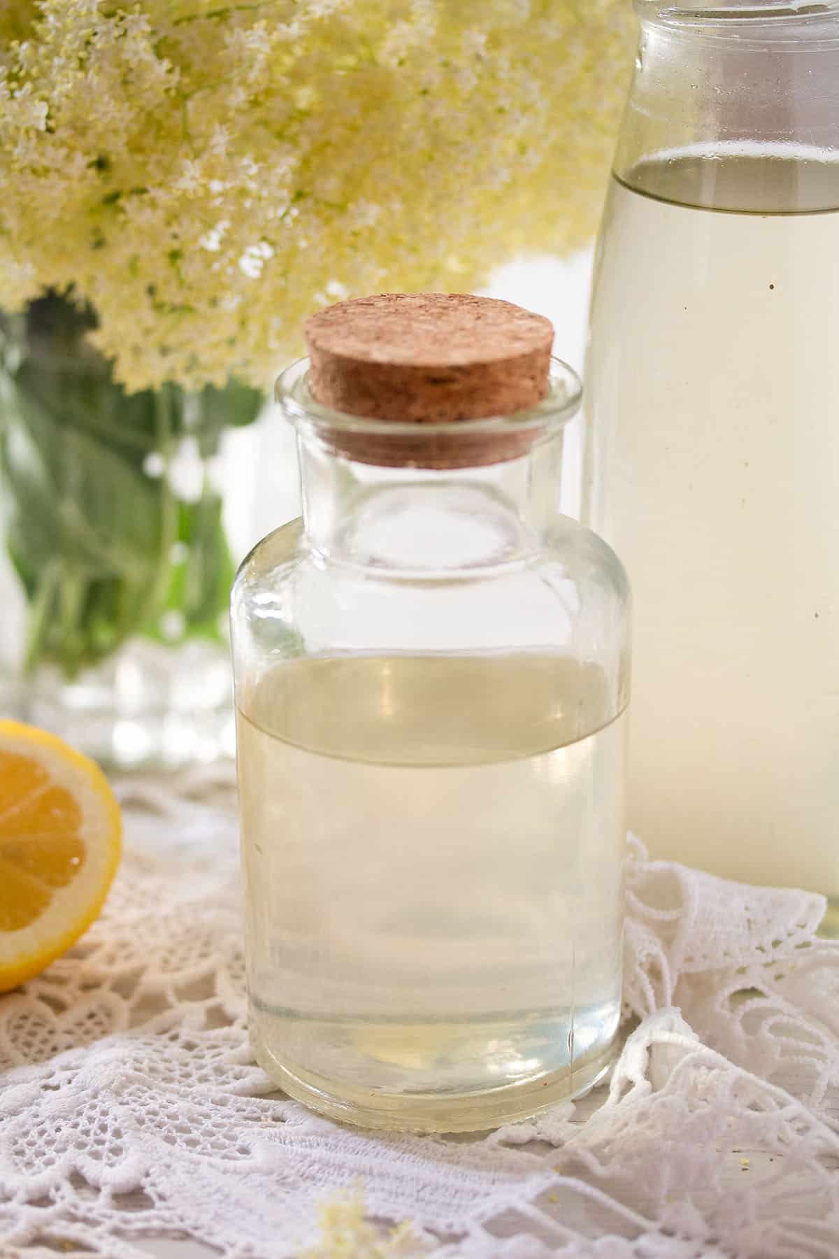 elderflower syrup in a bottle with a large cork lid.