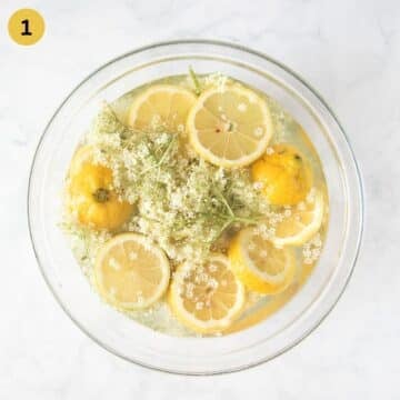 soaking elderflowers and sliced lemons in a large bowl to make syrup.