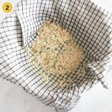straining elderflower soaked in water to make syrup using a kitchen cloth over a bowl.
