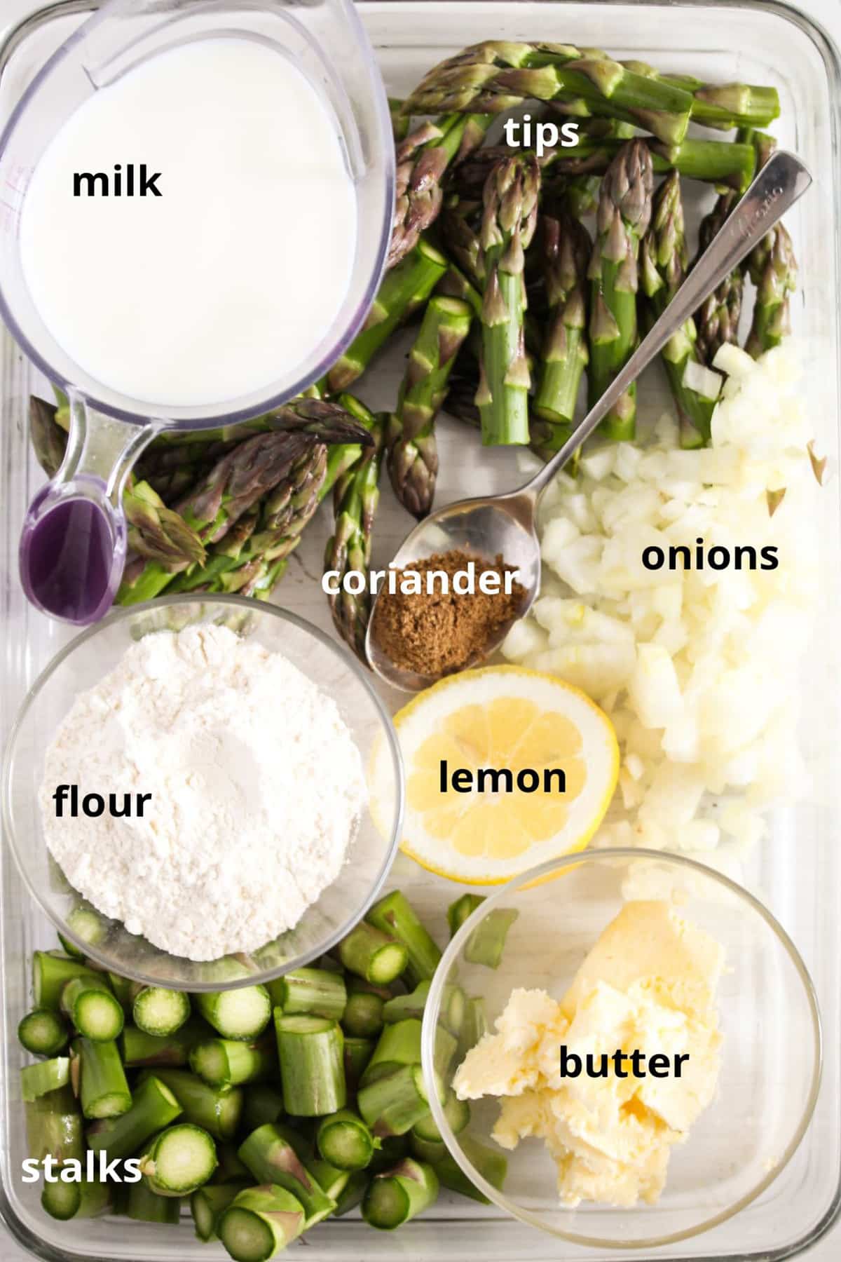 labeled ingredients for making creamy asparagus soup with milk.