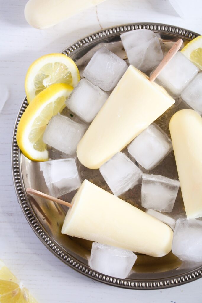 lemon popsicles with ice cubes and lemon slices on a plate