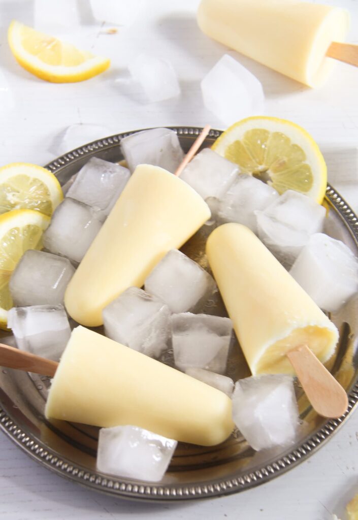 lemon ice lollies on a silver platter with ice cubes