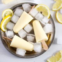 lemon popsicles with ice cubes and lemon slices on a plate