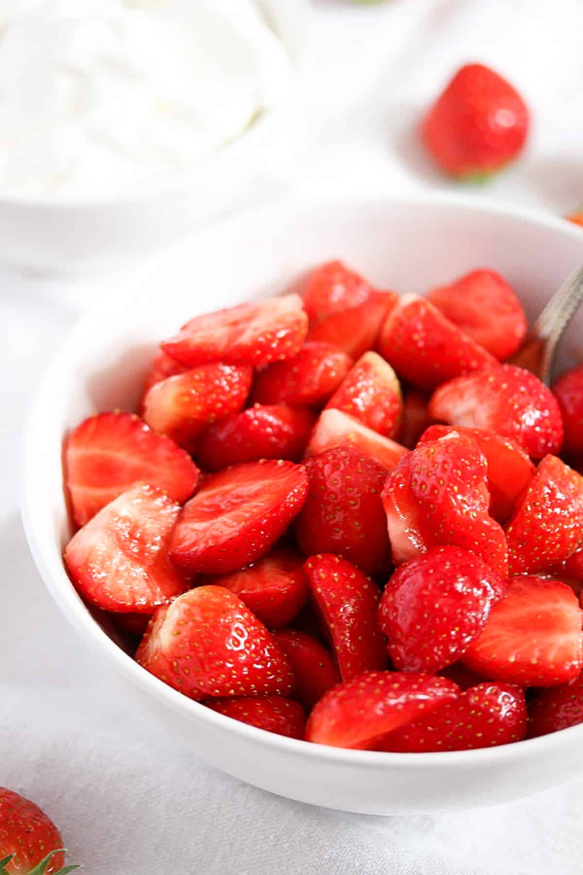 sugared strawberry halves in a small bowl.