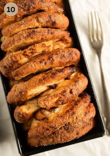 golden pull apart plum loaf in a baking tin.