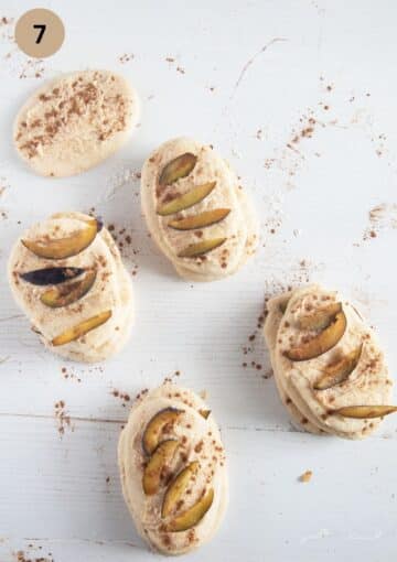 stacked pieces of yeast dough covered with sugar and butter mixture and sliced plums