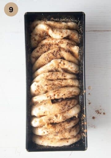 risen but unbaked yeast plum monkey bread in a baking pan.