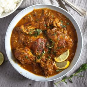 a bowl full of savory rhubarb chicken with lemon slices.