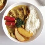 rhubarb chicken curry served with apple slices and rice in a bowl.