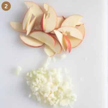 sliced apples and chopped onions on a cutting board.