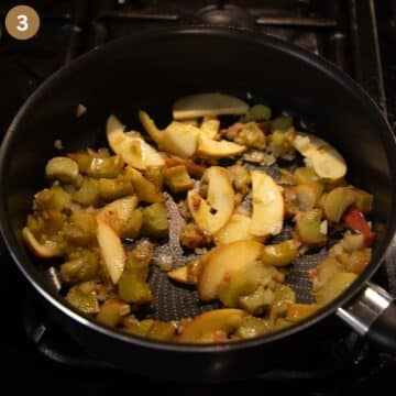 sauteing apple slices and rhubarb pieces in a saucepan to make curry.