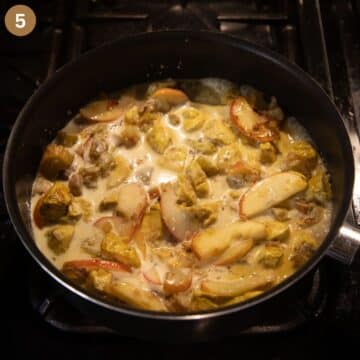 chicken, rhubarb and apple pieces simmering in coconut milk in a saucepan.