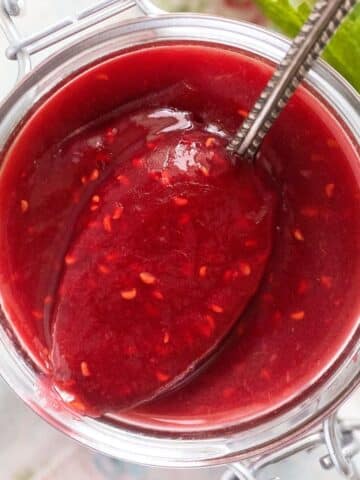 close up of rhubarb raspberry jam spooned from a jar.