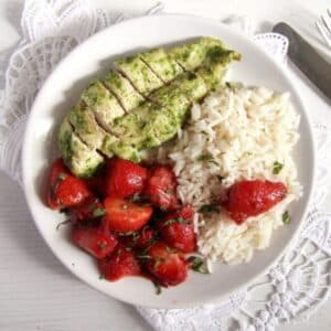 savory strawberry recipe with chicken breast, strawberry chutney and rice on a plate.