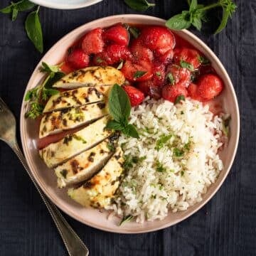savory strawberry chicken served with rice on a plate.