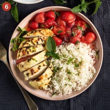 sliced chicken breast, strawberry sauce, and rice on a plate.