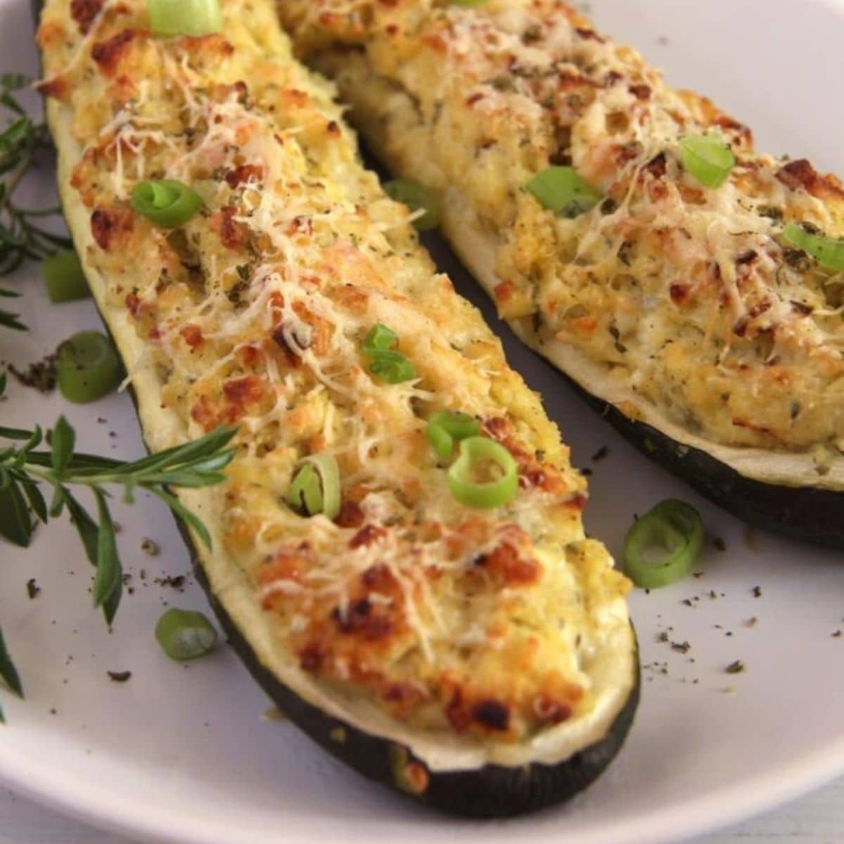 two vegetarian stuffed zucchini boats with grains, cheese and herbs.