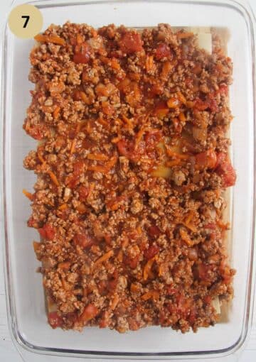 adding meat sauce to lasagna in a baking dish.