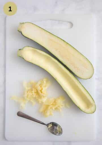 scooping the flesh out of zucchini halves using a teaspoon.
