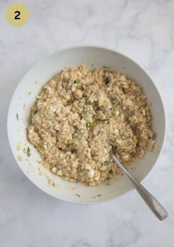 mixing cooked millet with cottage cheese and feta in a bowl.