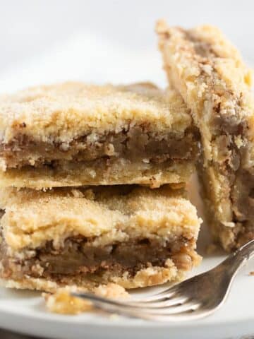 three pieces of apple hazelnut cake on a plate with a fork.