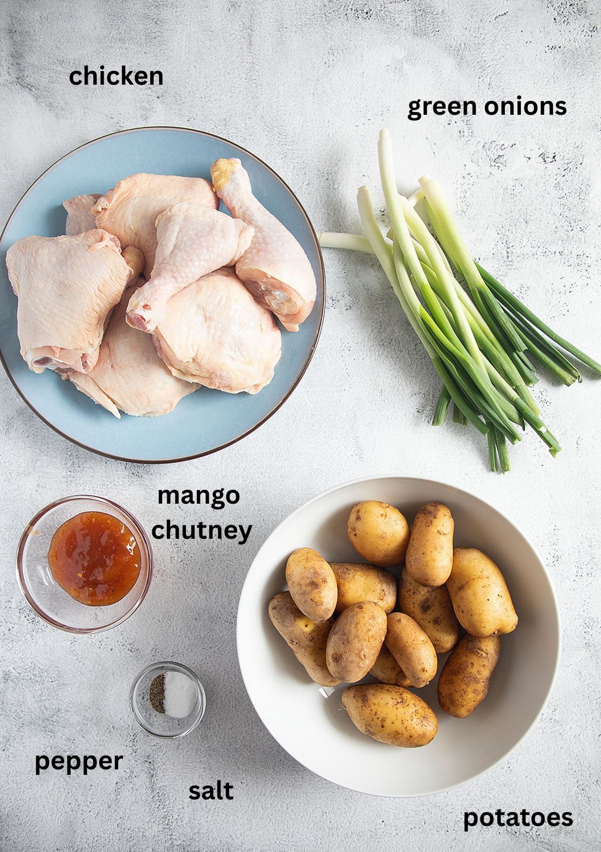 labeled ingredients for cooking chicken with potatoes, green onions and mango chutney.