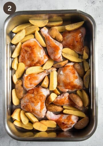 uncooked mango chicken and potatoes in a roasting pan.